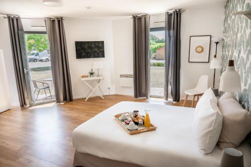 a bedroom with a bed with a tray of food on it at Hôtel & Séminaire Le Patio Occitan - Toulouse Ouest - La Ramée in Cugnaux