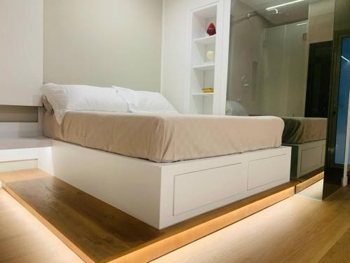 a bedroom with a white bed with a mirror at Il Rifugio di Gaia Apartment B&B in Reggio Calabria