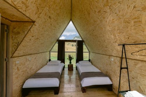 eine Reihe von Betten in einem Zimmer mit Fenstern in der Unterkunft OKON Highlands Cottages & Camp in Yenokavan
