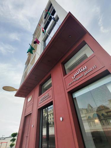 a red building with a sign on it at Baithans 24 Furnished Apartments Hotel LLC in Ajman 