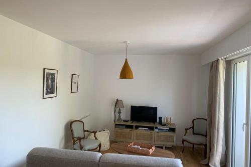 Una sala de estar con un sofá y un televisor. en Apartment with balconies close to the beach, en Tourgéville