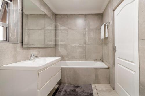 ein weißes Badezimmer mit Badewanne und Waschbecken in der Unterkunft #AlimamaSpaces Culross Cottage Retreat in Johannesburg