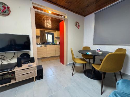 a living room with a table and a television at Surfers' Cottage in Anavissos