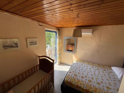 a small room with a bed and a window at Surfers' Cottage in Anavissos