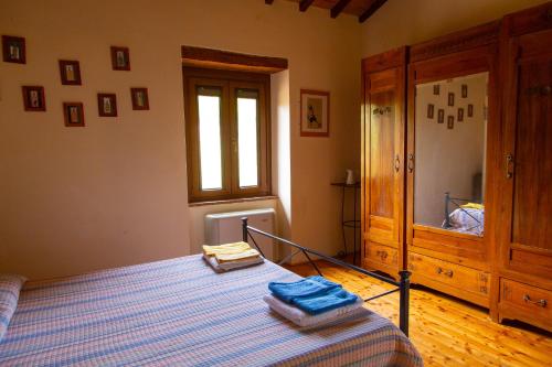 a bedroom with a bed with blue sheets and a window at Casale meraviglioso Val d'Orcia con piscina in Radicofani