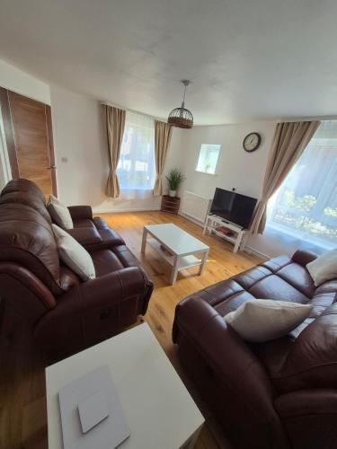 a living room with two couches and a table at Stylish 3 Bedroom House, Perfect for Families and Groups in Hull
