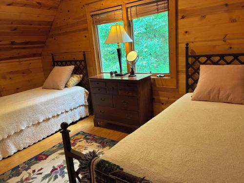 a bedroom with two beds and a window in a cabin at Sapphire Cabin at Splendor Mountain in Tiger