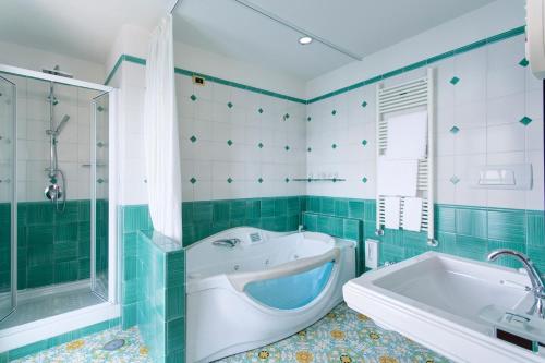 a bathroom with a tub and a shower and a bath tub at Lloyd's Baia Hotel in Vietri sul Mare