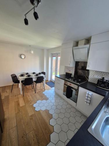 a kitchen with a table and chairs in a room at Stylish 3 Bedroom House, Perfect for Families and Groups in Hull