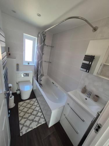 a white bathroom with a sink and a tub and a toilet at Stylish 3 Bedroom House, Perfect for Families and Groups in Hull