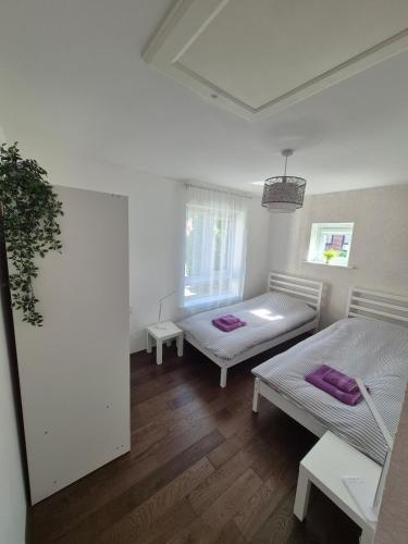 a white room with two beds and a window at Stylish 3 Bedroom House, Perfect for Families and Groups in Hull