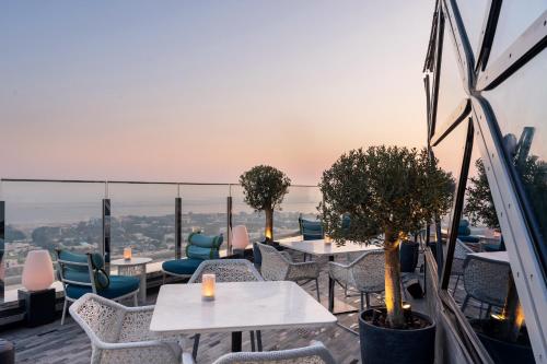 a restaurant with tables and chairs on a roof at Andaz Capital Gate Abu Dhabi, By Hyatt in Abu Dhabi