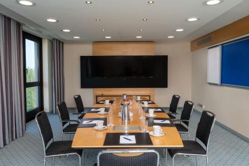 a conference room with a large table and a flat screen tv at Maritim Hotel Düsseldorf in Düsseldorf