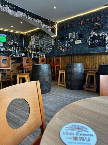 a bar with barrels and a table and chairs at Holiday Home 憩 -IKOI- in Loftus