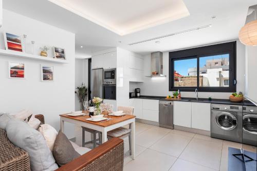 a kitchen and a living room with a table and a couch at MEDANO4YOU Tina's Jacuzzi Terrace Playa Chica in El Médano