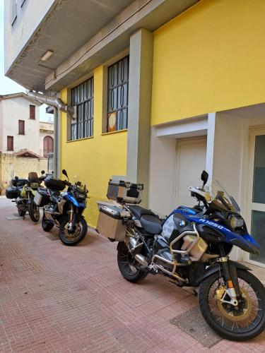 a row of motorcycles parked outside of a building at CENTRAL ROOMS TORTOLI' in Tortolì