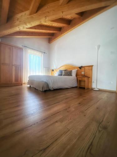 a bedroom with a bed and a wooden floor at Eco-Baita Natura Spensierata in Canale San Bovo