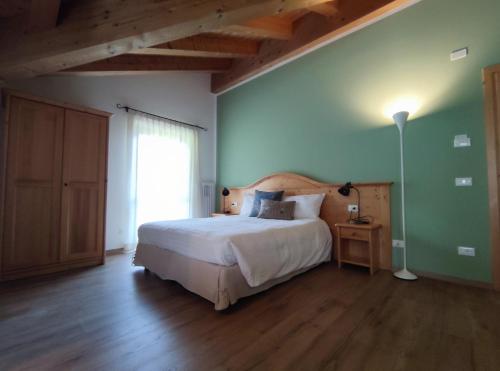a bedroom with a bed and a green wall at Eco-Baita Natura Spensierata in Canale San Bovo
