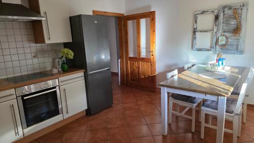 a kitchen with a stainless steel refrigerator and a table at Große Landhaus Wohnung 30 Min bis Hamburg in Klein Offenseth-Sparrieshoop