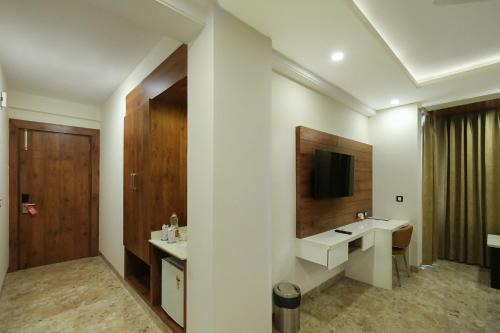 a bathroom with two sinks and a tv on the wall at FabHotel Golf Inn - Business-Friendly Stay near Golf Course Road, Cyberhub & Metro in Gurgaon
