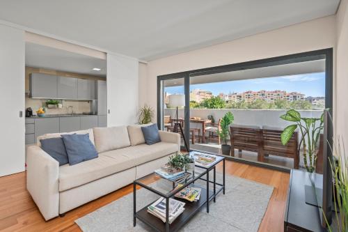 a living room with a couch and a table at Rooftop Pools & Balcony Haven by HostWise in Faro