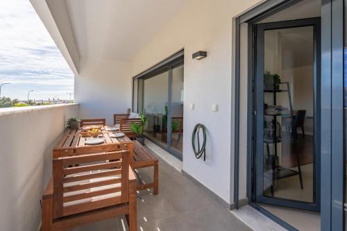 a balcony with a wooden table and chairs at Rooftop Pools & Balcony Haven by HostWise in Faro