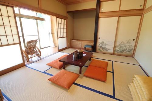 a room with a table and orange cushioned chairs at おどろき荘 in Shirako