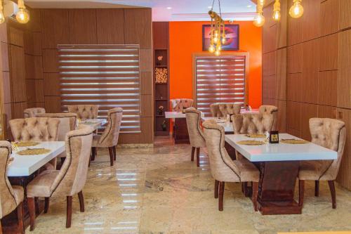 a dining room with white tables and chairs at Cardiff Resort in Makurdu