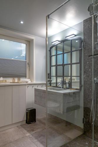 a bathroom with a sink and a glass shower at Sönshörn 16 in Munkmarsch