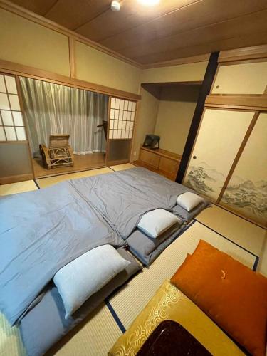 a bedroom with a large bed with pillows on it at おどろき荘 in Shirako