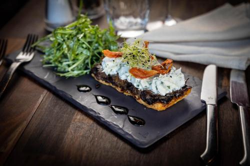 a plate with a sandwich and a salad on a table at The Originals Boutique, Hôtel d'Alsace, Strasbourg Sud in Illkirch-Graffenstaden