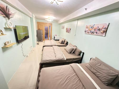a row of beds in a room at Kathys Crib Family Suite Room at Shell Residence in Manila
