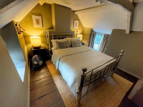 ein Schlafzimmer mit einem großen Bett in einem Zimmer in der Unterkunft Well Cottage, Thames St in Charlbury