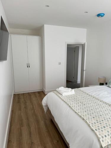 a white bedroom with a bed and white cabinets at Nest in Northumberland in Blythe
