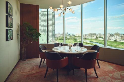 a dining room with a table and chairs and windows at InterContinental Sapporo by IHG in Sapporo