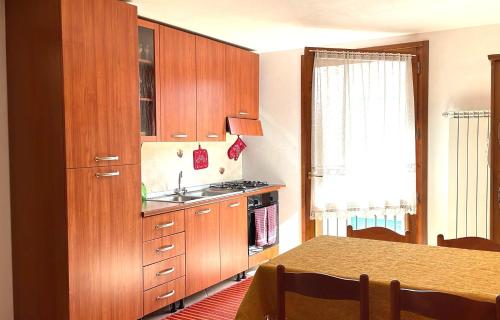 a kitchen with wooden cabinets and a sink at Pink Grumello in Schilpario