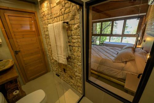 a bathroom with a shower and a bed in a room at Cabana Rústica em Gramado in Gramado