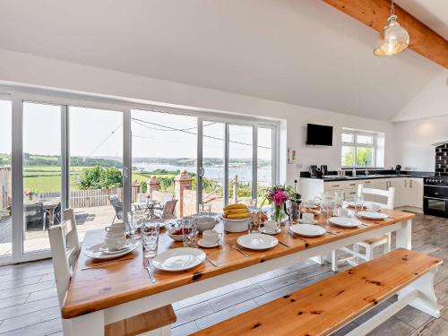 インストウにある11 Bed in Instow REDLAのテーブルと大きな窓のあるダイニングルーム