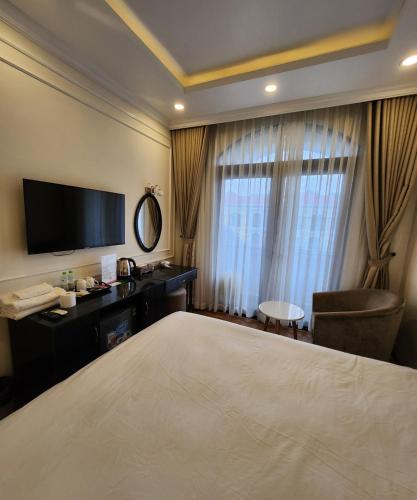 a hotel room with a bed and a desk and a television at BREAKING DAWN- TAEYANG Hotel Phú Quốc in Phu Quoc