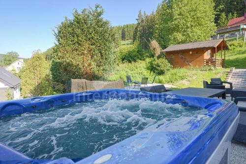 a large blue pool of water in a backyard at Ski/Bike Villa Sapporo ⃰ ⃰ ⃰ in Kraslice
