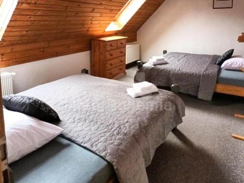 a bedroom with two beds and a wooden wall at Ski/Bike Villa Sapporo ⃰ ⃰ ⃰ in Kraslice