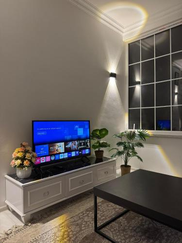 a living room with a large flat screen tv on a cabinet at Guba White House in Uçgün