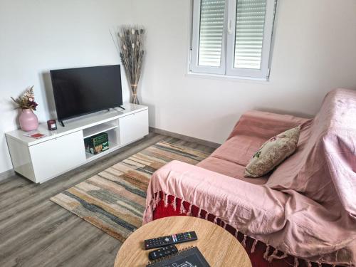 a living room with a couch and a flat screen tv at Marca 34 in Monção