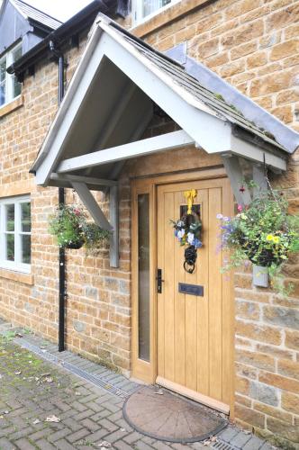 an awning over the door of a brick house at Hedges in Hook Norton