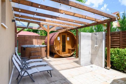 a patio with a wooden pergola and a tub at Molnár Apartman Zamárdi in Zamárdi