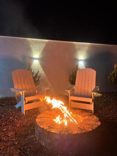 two chairs sitting around a fire pit at night at Guba White House in Uçgün
