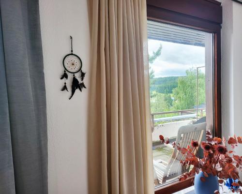 Deck-Apartment next to the forest, indoor fireplace, free parking في سخوناخ: ساعة معلقة على جدار بجوار النافذة