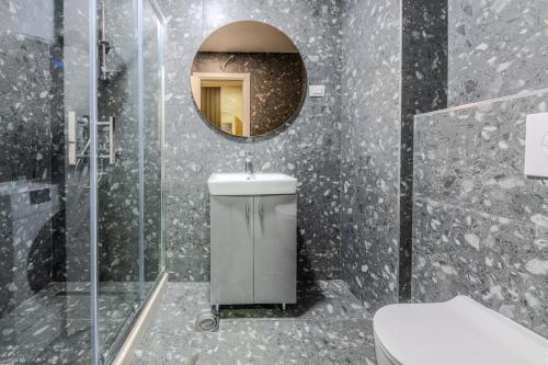 a bathroom with a toilet and a mirror at Impressive Premium Apartment in Nikšić