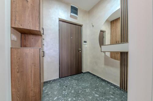 a hallway with a wooden door and a staircase at Impressive Premium Apartment in Nikšić