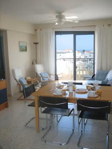 a living room with a table and chairs and a couch at Penthouse Apartment Latchi Cyprus in Lachi